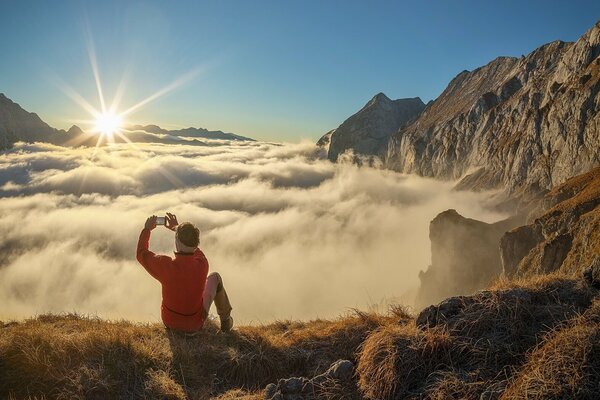 Titelbild Nouveaux Horizons: Eine Person steht auf einem Berg und fotografiert den Horizont.