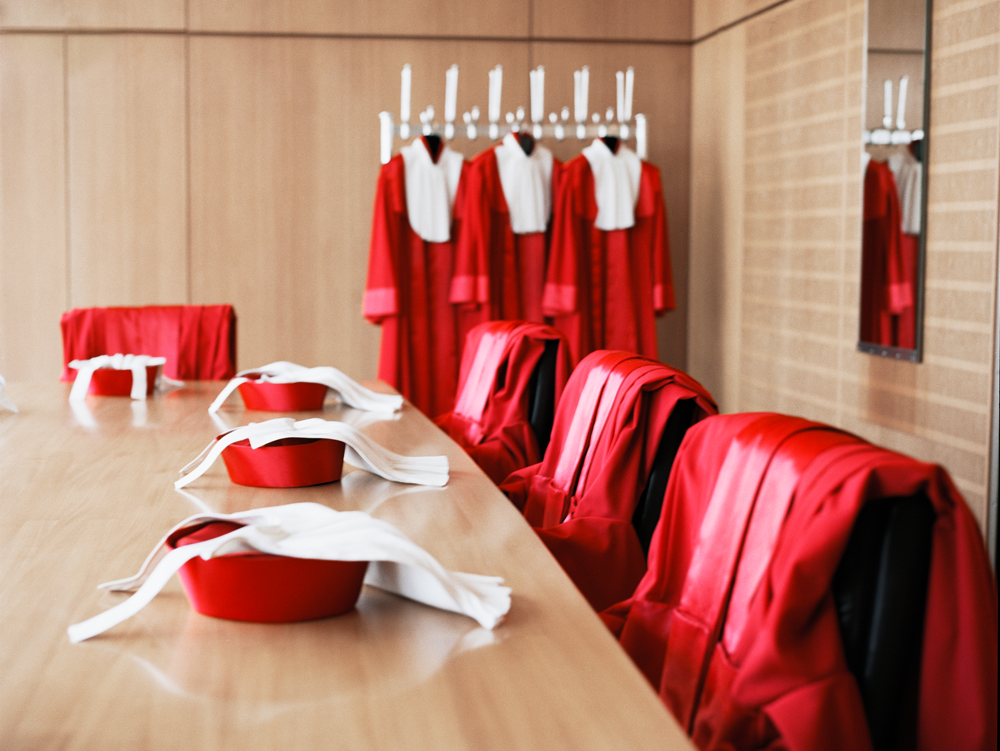 Hinterzimmer des Bundesverfassungsgerichts mit hängenden Roben und Hüten auf dem Tisch