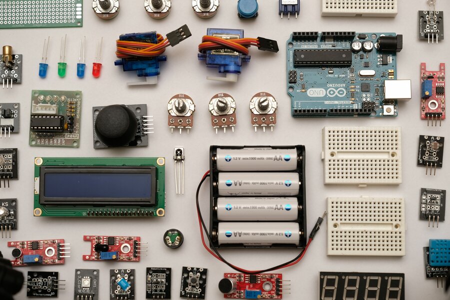 Das Foto zeigt viele elektrische Bauteile, die auf einer Oberfläche nebeneinander liegen.